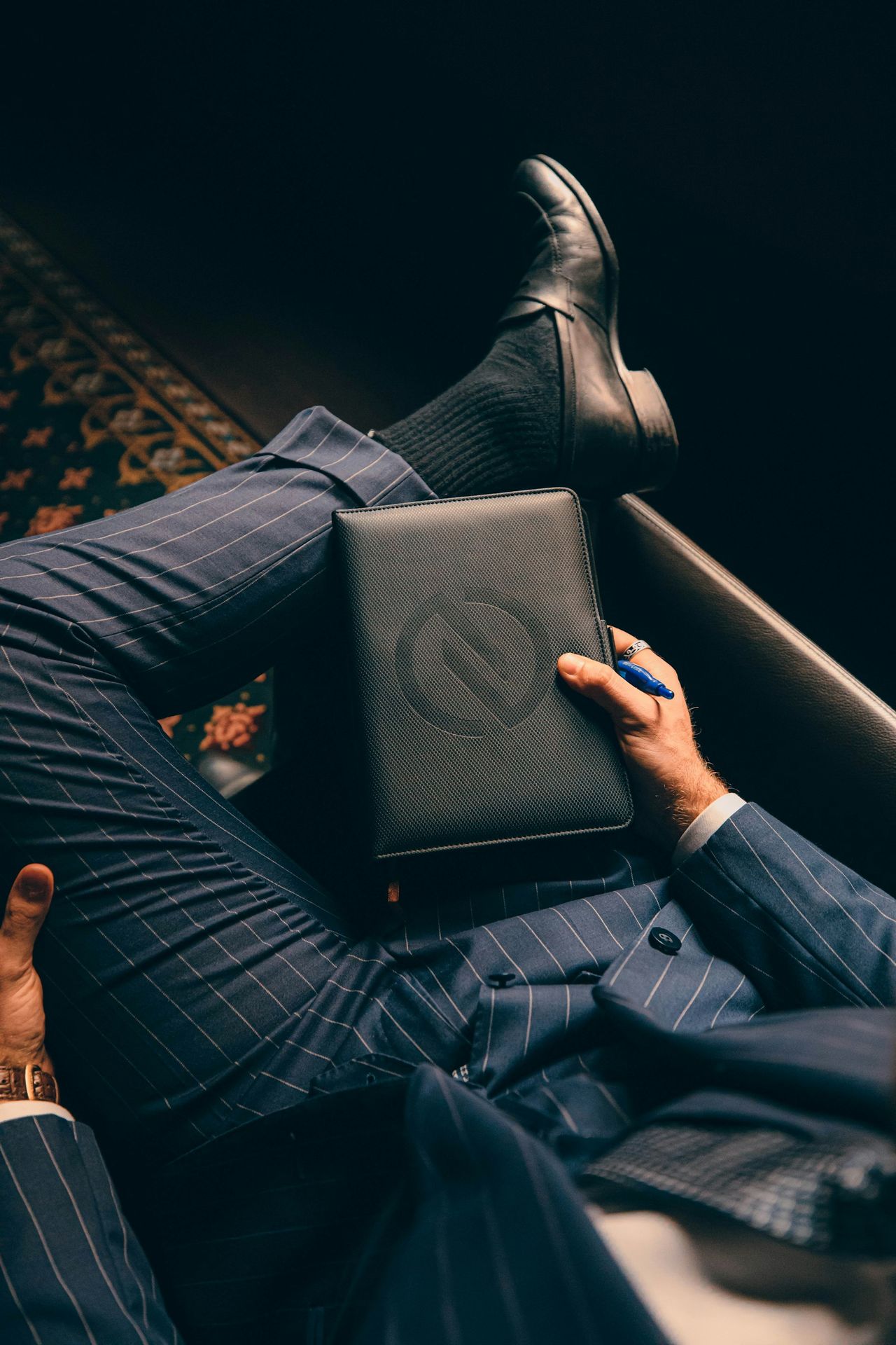 a man in a suit is holding a laptop