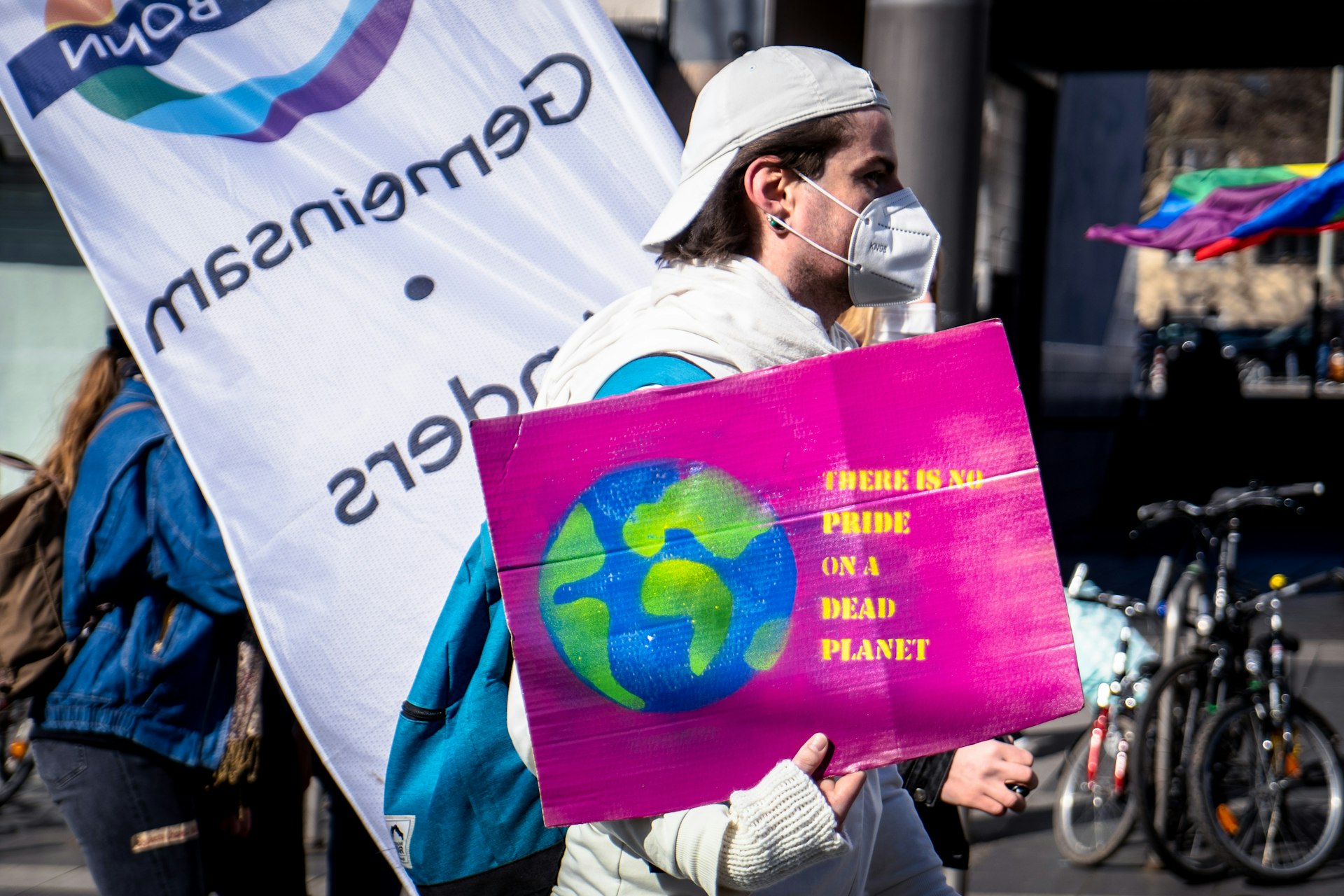 man in white jacket holding purple and white banner